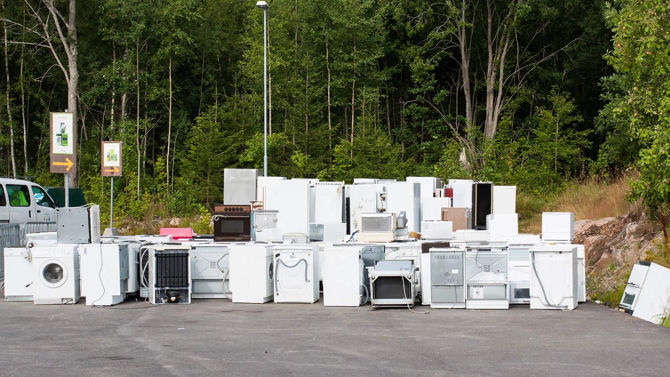 A pile of appliances sitting in the middle of a parking lot.