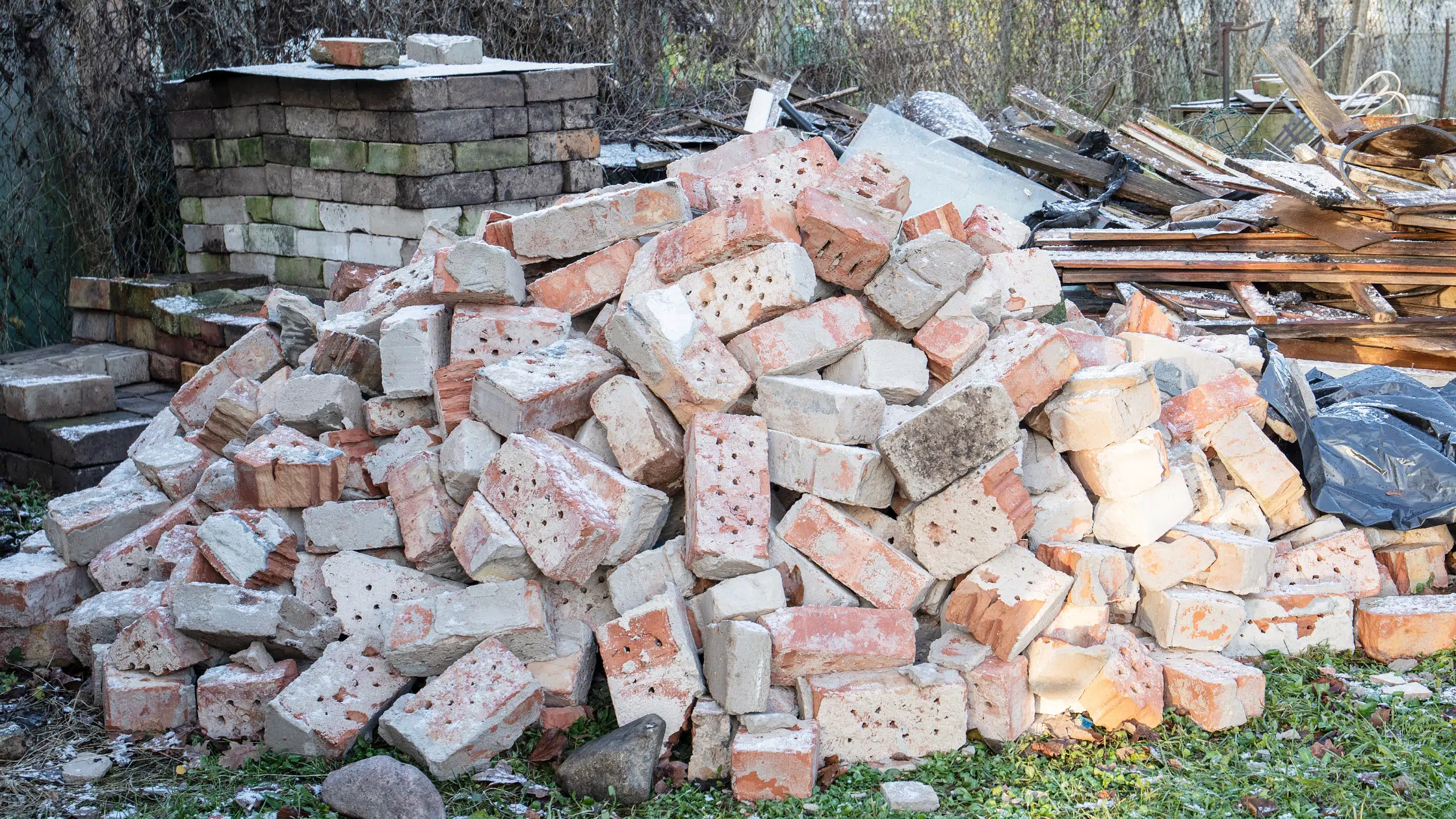 A pile of bricks sitting in the grass.