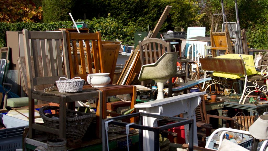 A pile of chairs and tables in the yard.
