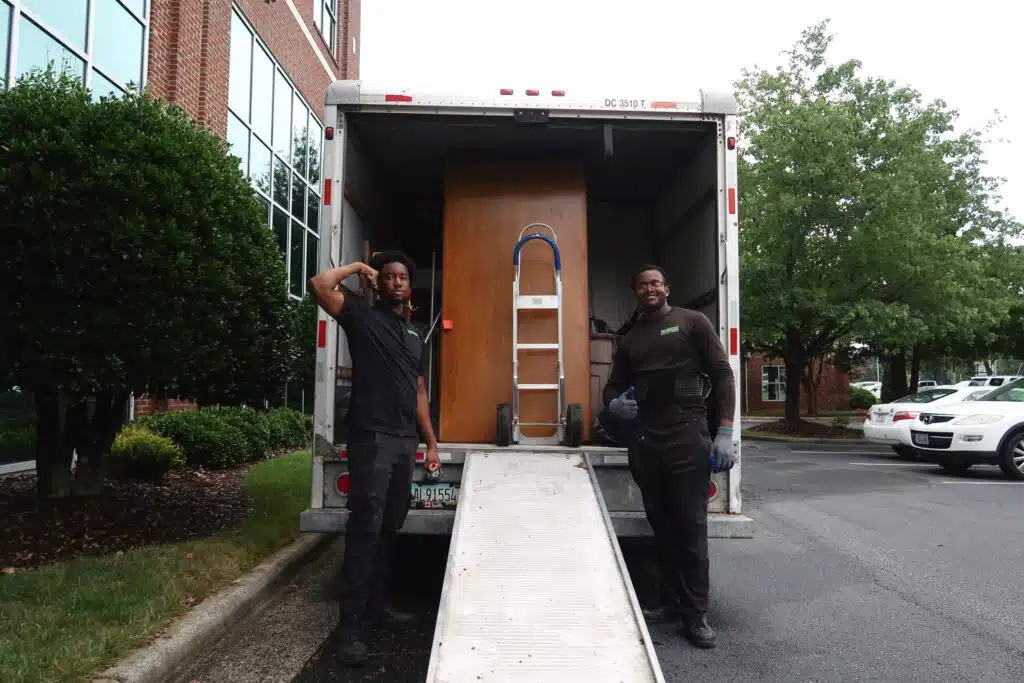 Two men standing in front of a moving truck.