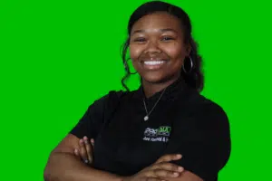 A woman standing in front of a green background.