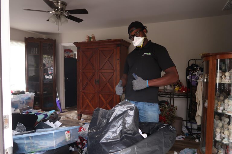 Pro Hauling crew member clearing debris during a hoarder cleanup in Greensboro, NC.