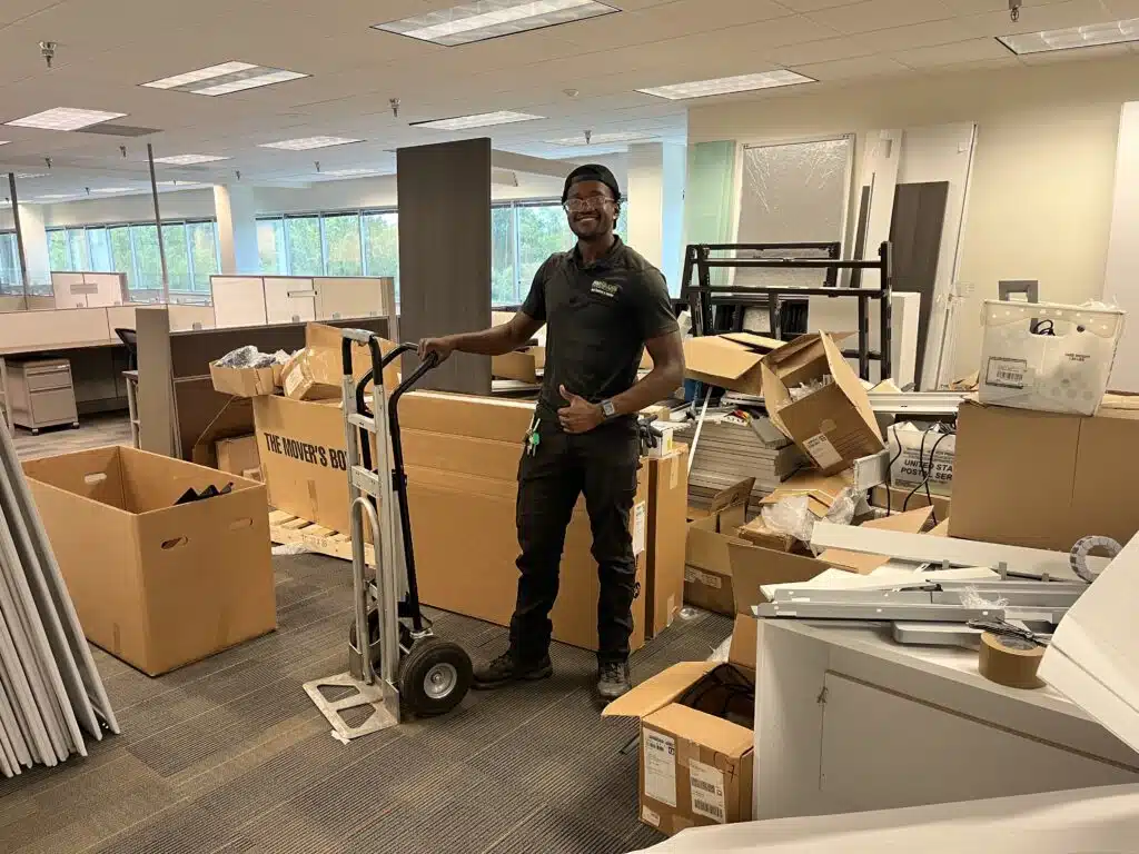 Crew member performing an office cleanout in Greensboro, NC, removing desks, chairs, and old office furniture.