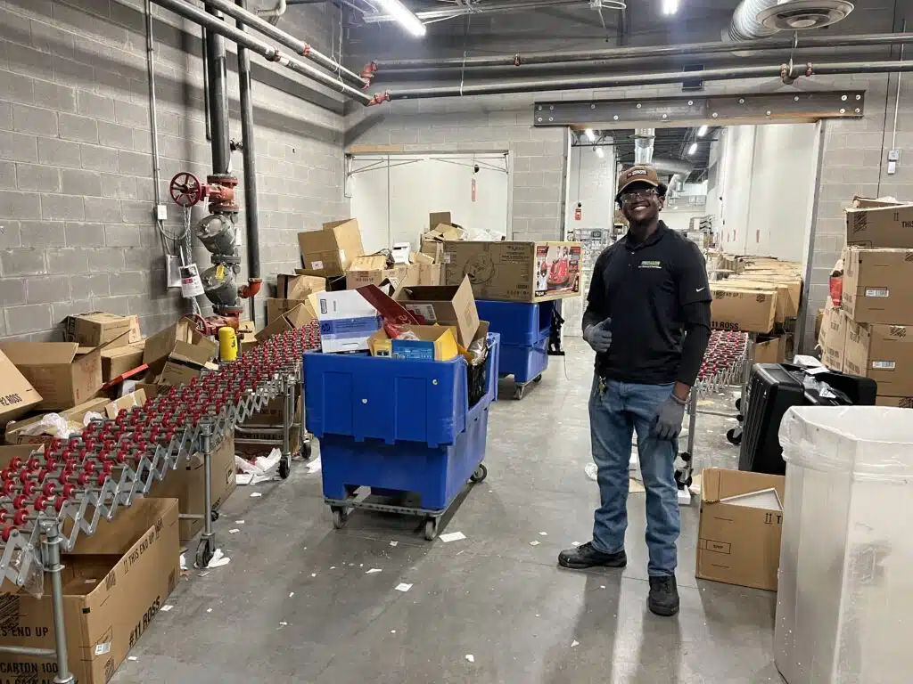 Crew member loading pallets and warehouse debris into a Pro Hauling truck during a warehouse cleanout in Greensboro NC
